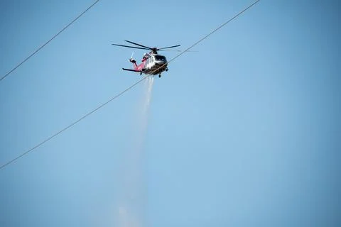 A helicopter from the LAFD performs a water drop and observation during a bru Foto stock