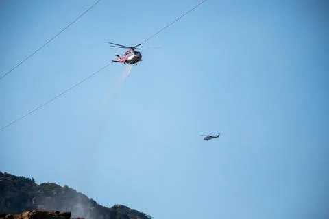 A helicopter from the LAFD performs a water drop and observation during a bru Foto stock