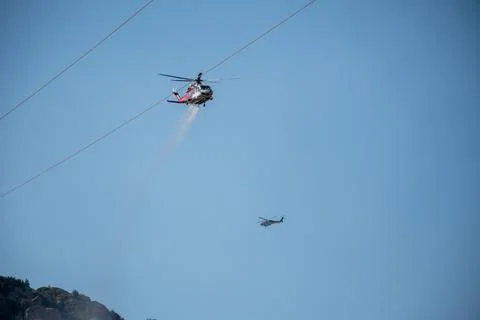 A helicopter from the LAFD performs a water drop and observation during a bru Foto stock