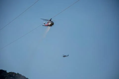 A helicopter from the LAFD performs a water drop and observation during a bru Foto stock