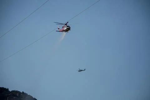 A helicopter from the LAFD performs a water drop and observation during a bru Stock Photos
