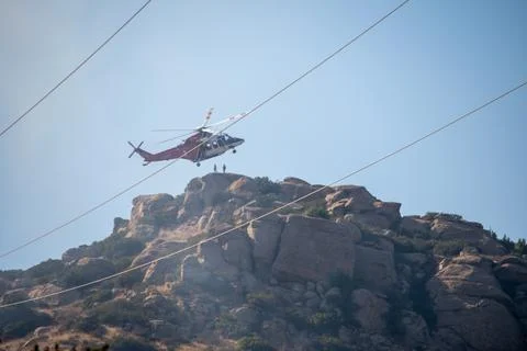 A helicopter from the LAFD performs a water drop near firefighters at a brush Foto stock