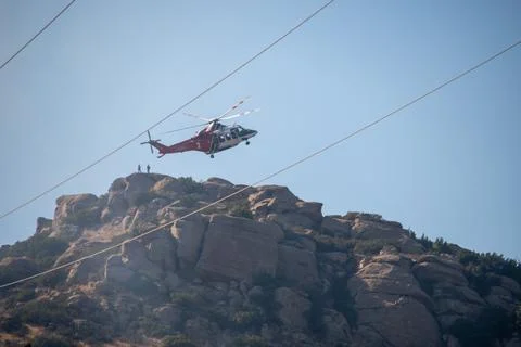 A helicopter from the LAFD performs a water drop near firefighters at a brush Foto stock