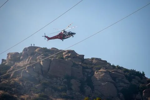 A helicopter from the LAFD performs a water drop near firefighters at a brush Foto stock
