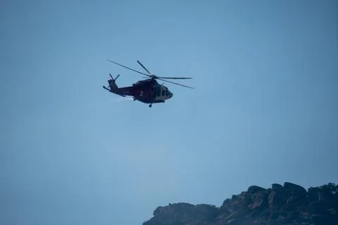 A helicopter from the LAFD performs a water drop and observation during a bru Foto stock
