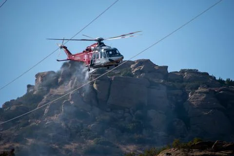 A helicopter from the LAFD performs a water drop and observation during a bru Foto stock