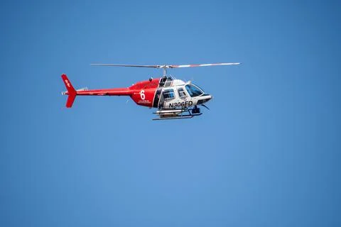 A helicopter from the LAFD performs a water drop and observation during a bru Stock Photos