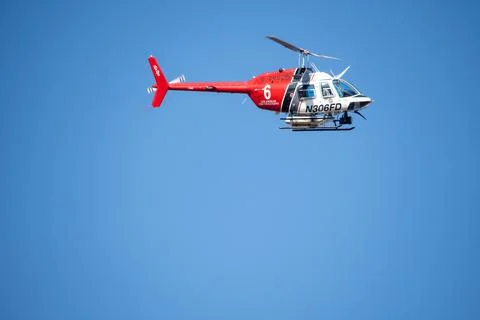 A helicopter from the LAFD performs a water drop and observation during a bru Foto stock