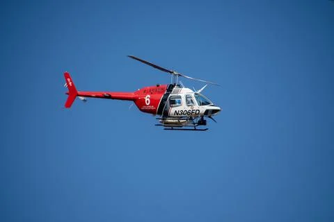 A helicopter from the LAFD performs a water drop and observation during a bru Foto stock