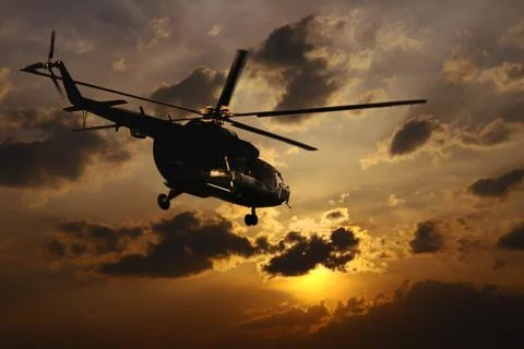 Helicopter landing at sunset Stock Photos
