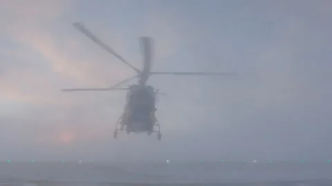 Helicopter lands in clouds of dust. Front view. Green lights of helipad. Stock Footage 218592289