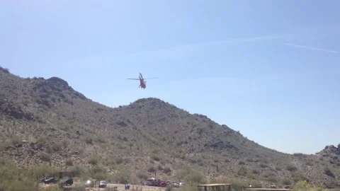 Helicopter Leaves Mountain Range after Performing Emergency Mountain Rescue  Stock Footage 233899001