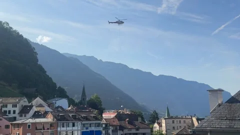 Helicopter Lifting Cargo Over Swiss Alpine Village Stock Footage 337930227