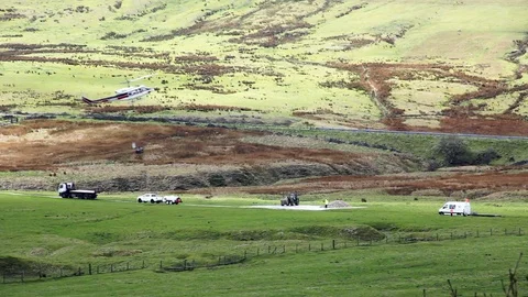 Helicopter moving building materials in an underslung hopper Peak District Stock Footage 80144823