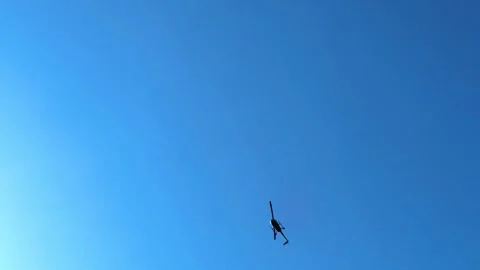 A helicopter overhead flying in the blue sky during the day. Stock Footage 296308666