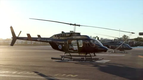 Helicopter parked at a hanger with sun setting and blue sky. Stock Footage 135797599