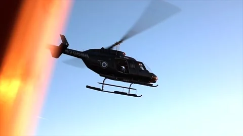 Helicopter parked at a hanger with sun setting and blue sky. Stock Footage 135797617
