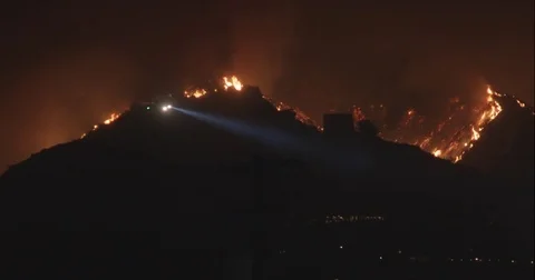 Helicopter passes flames Stock Footage 79605016