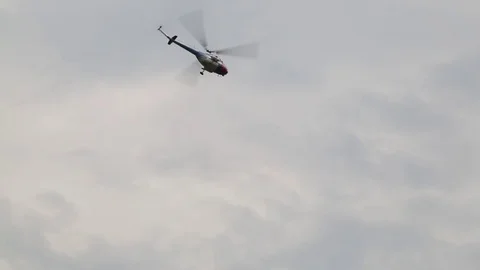 The helicopter performs aerobatics figures in the sky. Shooting from the ground. Stock Footage 81185553