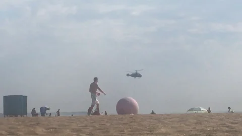 Helicopter is picking up water on the beach Stock Footage 93907320