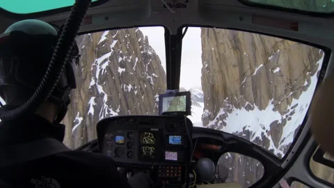 Helicopter pilot flying through a snowy mountain pass Stock Footage 335083780