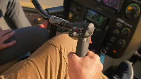 Helicopter pilot holding the control lever of the Robinson R66  Stock Footage 200808382