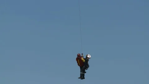 Helicopter pulling firefighters up during rescue training exercise Stock Footage 116469318