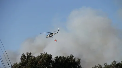 Helicopter races towards fire to drop water Stock Footage 114413649