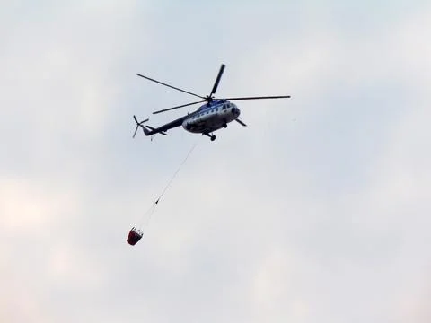 A helicopter returns from extinquishing a fire Stockfoto's