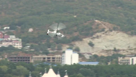 Helicopter Rotorfly R-30 performs aerobatics on blurred background of mountain. Stock Footage 131583638
