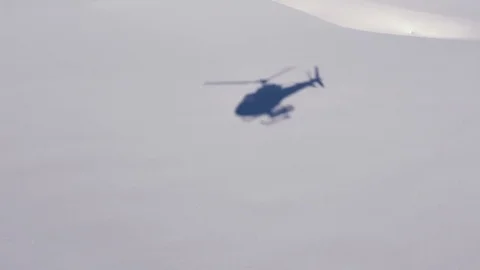 Helicopter Shadow on Snow Field coming in for landing Stock Footage 72915623