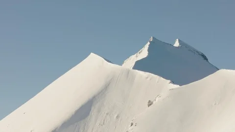 Helicopter shot flying towards a massive snow-covered mountain Stock Footage 101912437