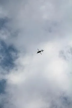 Helicopter in the sky with white clouds Stock Photos