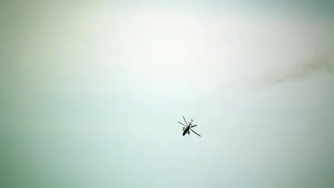 Helicopter Soars High in a Vast and Cloudy Sky Above Stock Footage 319536656