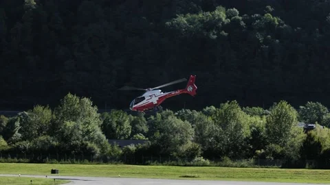 Helicopter Taking Off and Flying over Lugano Airport Against Sky with Mountain Stock-Footage 211402599
