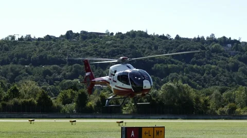 Helicopter Taking Off and Flying over Lugano Airport Against Sky with Mountain Stockbeeldmateriaal 211402915