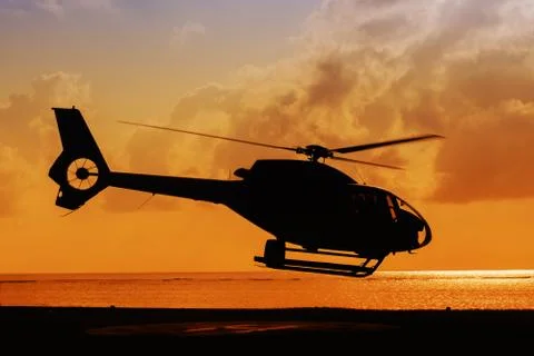 Helicopter taking off at sunset Stock Photos