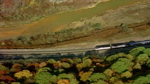 Helicopter tracking shot of train coming around the mountain 스톡 동영상 29803989