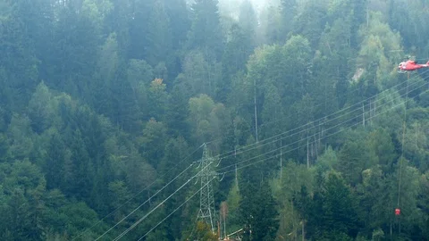 Helicopter transporting cement to construction site in alps Stock Footage 70581124