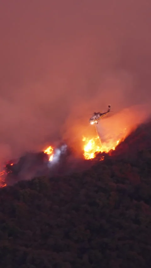 Helicopters are combating a major fire threatening Malibu and Pacific Palisades Stock Footage 299676488