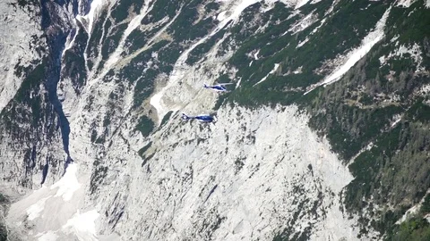 Helicopters hovering over snow covered mountain in slow motion Stock Footage 71568225