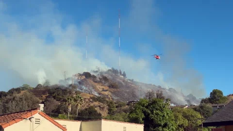 Helicopters water drop on hill fire - 4KUHD Stock Footage 344516862