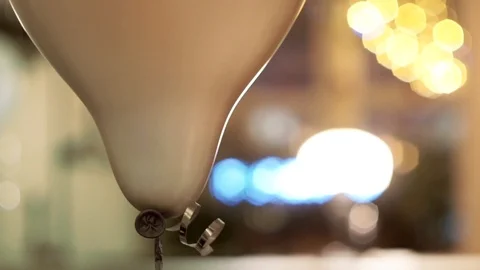 Helium white sphere balloon with silver tape in warm holiday atmosphere,close-up Stock Footage 107777868