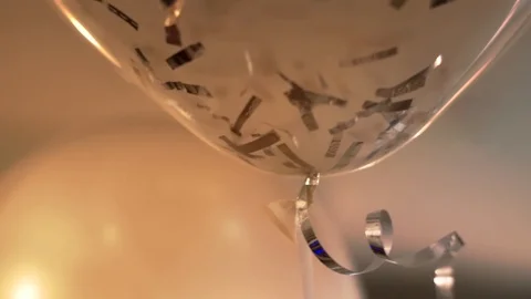 Helium white sphere balloons with silver confetti in warm holiday atmosphere Vídeo Stock 107777919