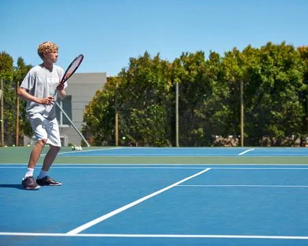 Hell be a start one day. a young boy playing tennis on a sunny day. Stock Photos
