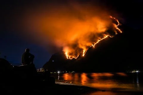 Hell on Como lake, the Moregallo peak wrapped by burning flames Stock Photos