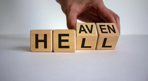 Hell or heaven. Hand turns a cube and changes the word 'hell' to 'heaven'. Co Stock Photos