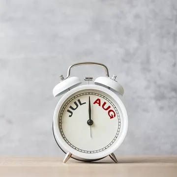 Hello August  Changed from July month with vintage alarm clock on table bac.. Stock Photos