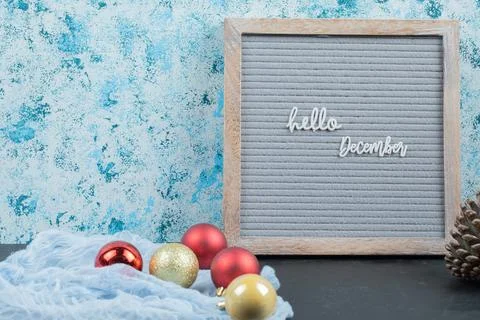 Hello december phrase on the grey board with christmas bubbles around Stock Photos