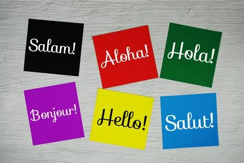 Hello in different languages text on stick note on concrete background Stock Photos
